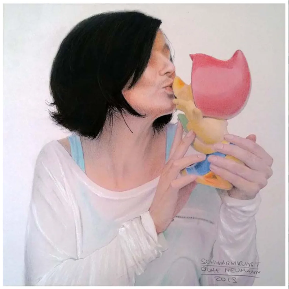 Pastell: Frau küsst eine bunte Spielzeugfigur
